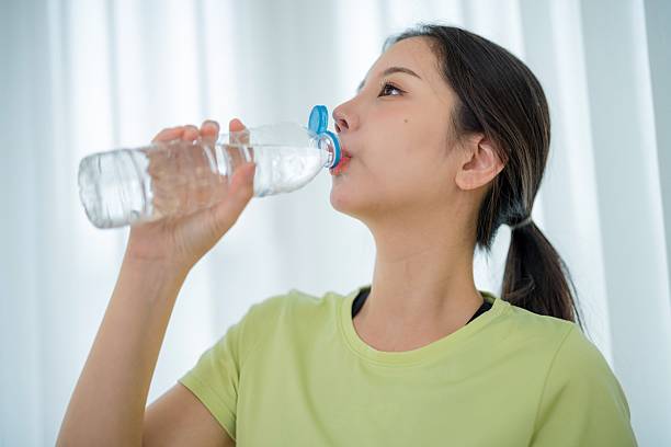istock Woman enjoying hydration while relaxing indoors in a light-filled room during daytime 2204172437