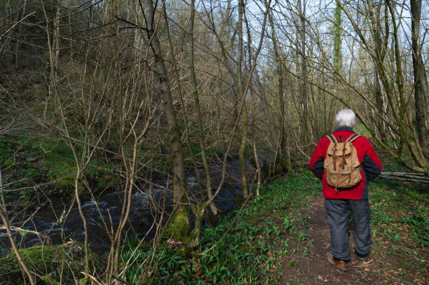 istock Retired man walking on a footpath beside a stream 2204180779