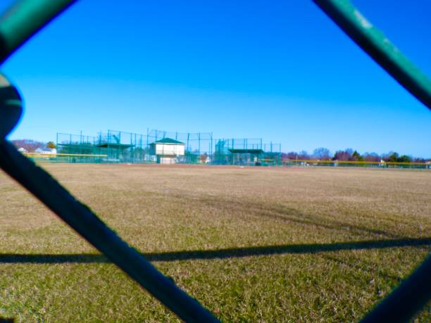 istock Baseball field on sunny day from behind Chainlink fence. 2204182633