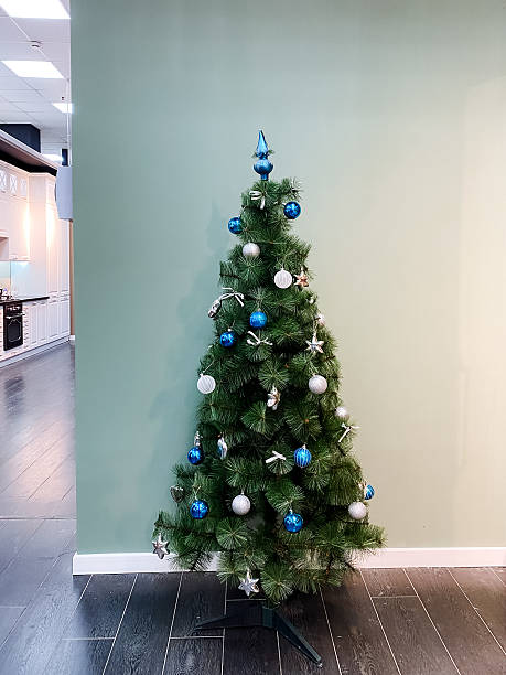 istock A beautifully decorated Christmas tree is sitting elegantly in a cozy room next to a wall, bringing a festive spirit to the space and celebrating the joy of the holiday season 2204183693