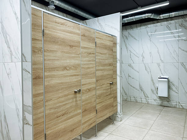 istock A public restroom featuring elegantly designed wooden stalls complemented by luxurious marble walls, creating an inviting atmosphere for users. The overall design reflects modern aesthetics 2204183741