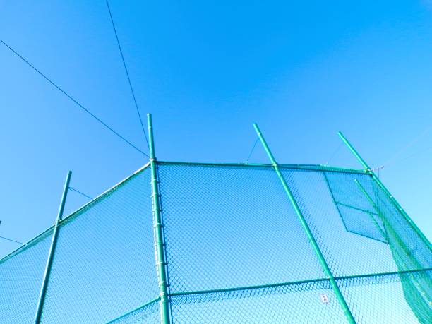 istock Baseball chainlink fence on sunny day with blue sky. 2204184180