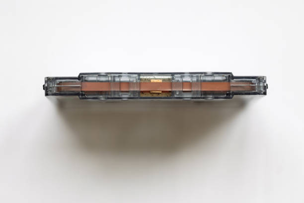 Close-up of a vintage audio cassette tape lying on a white background, showcasing its retro design