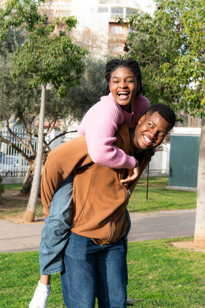 istock Students piggybacking in a city park 2204191150