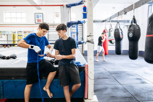 istock Teenage fighters wrapping hands, preparing to spar 2204191253