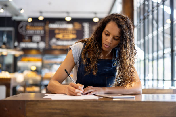 istock Business manager bookkeeping while working at a cafe 2204192540