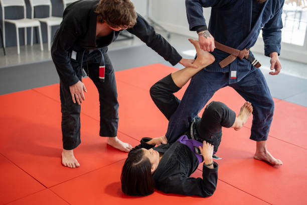 istock Gi BJJ Drill: Purple Belt Working Leg Technique with Coach and Teammate 2204197266