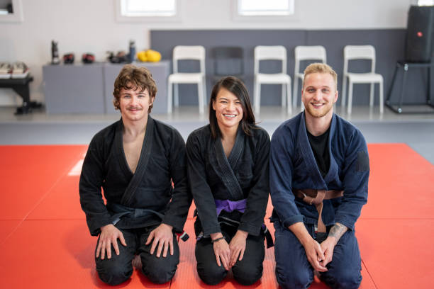 istock Jiu Jitsu Team Kneeling on the Mat with Smiles 2204197281