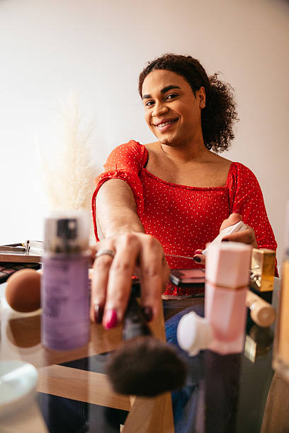 istock Smiling transgender woman applying makeup while smiling to the camera 2204198005