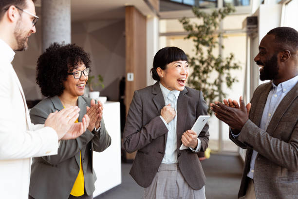 istock Office team applauding a happy colleague 2204198358