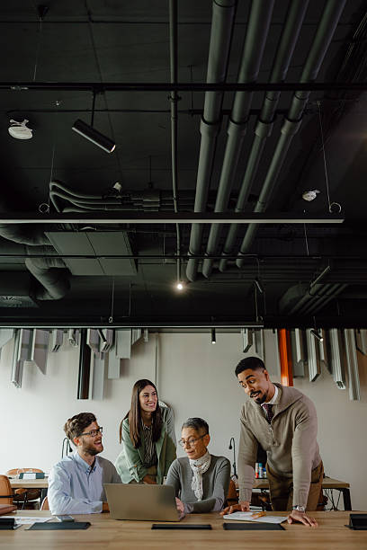 istock Diverse Team Collaborating on a Laptop in a Modern Industrial Office 2204206688