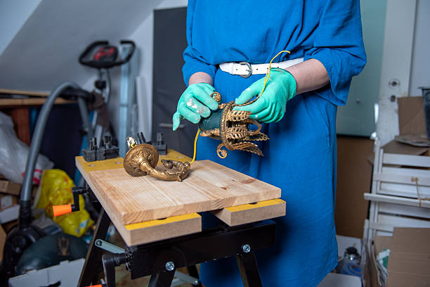 Restoring antique brass chandelier in workshop. stock photo