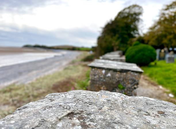 istock Close-up of weathered stone wall overlooking a beach 2204211273