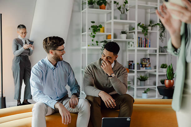istock Colleagues Sharing a Moment of Laughter in a Bright Office Setting 2204211589