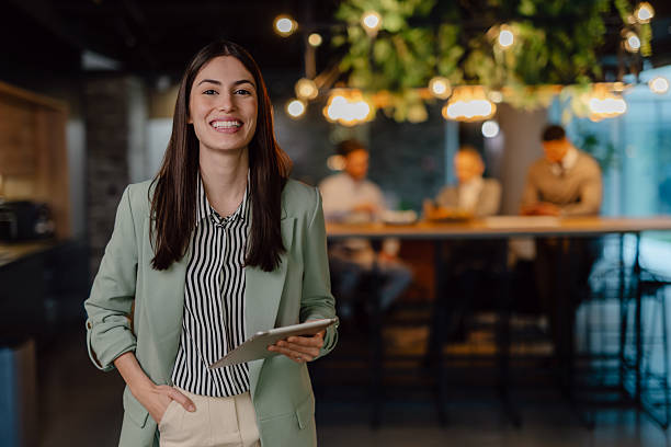 istock Smiling Professional Woman Holding Tablet in Elegant Modern Office Setting 2204211698