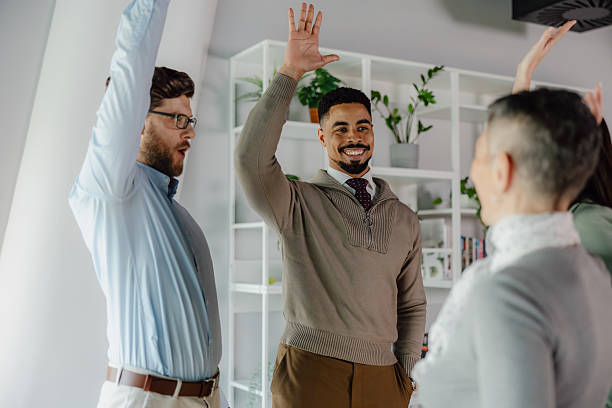 istock Diverse Team Celebrating Success With High Fives in Modern Office Setting 2204211711