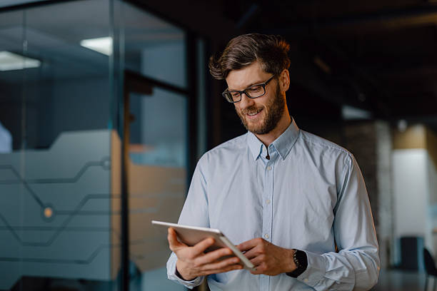 istock Professional Man With Tablet in Modern Office Setting, Smiling Confidently 2204211833