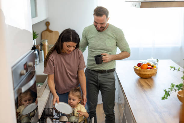 istock Family doing dishes together in modern kitchen 2204212277