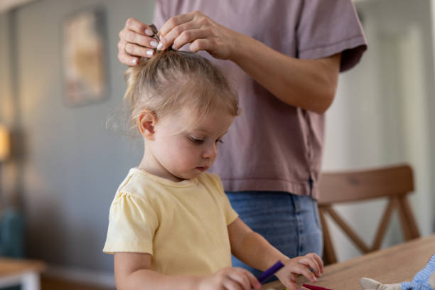istock Mother making daughter's hair before playing with colored pencils 2204213611
