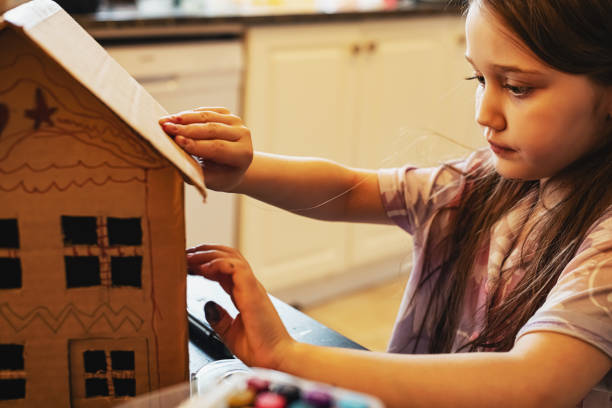 istock Girl Decorates Cardboard Home 2204213740