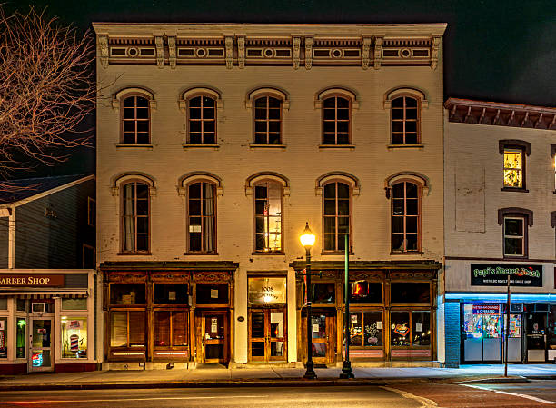 Peekskill, NY - US - Mar 7, 2025 Historic three-story brick building on Main Street in Peekskill, NY, lluminated by a streetlamp. It features arched windows and ornate cornices, with a vintage charm.