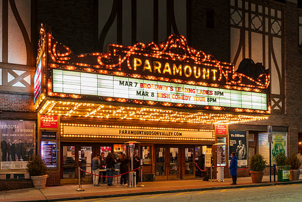 Peekskill, NY - US - Mar 7, 2025 A beautifully lit Paramount Theater at night in Hudson Valley, showcasing a classic marquee with upcoming events, a welcoming entrance, and a vibrant atmosphere.