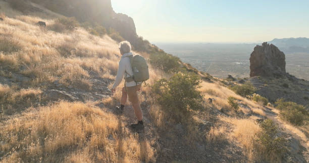 istock Mature man hikes up mountain in desert 2204216212