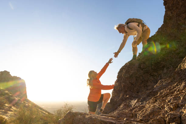 istock Hiker offers a helping hand in desert at sunset 2204216308