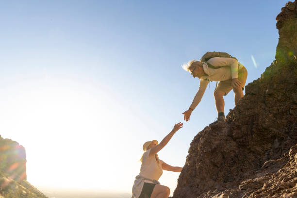 Hiker offers a helping hand in desert at sunset