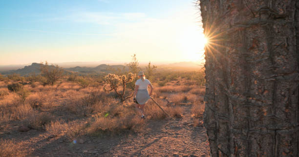 istock Woman hikes pathway in desert landscape at sunset 2204217156