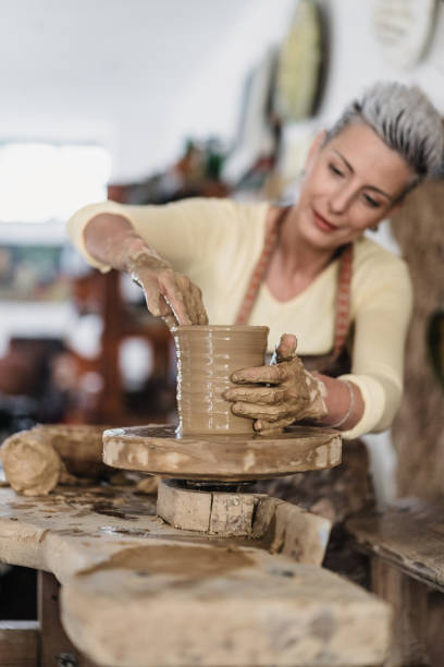 istock Beautiful female clay artist working on a pot 2204219187