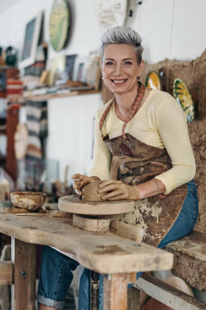 istock Beautiful female potter making a clay bowl 2204219201
