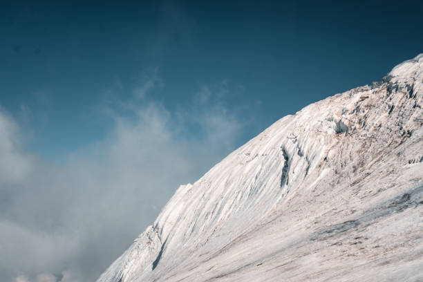 View up glacier and crevasses to mountain peak in moody light, Valais, Swiss Alps