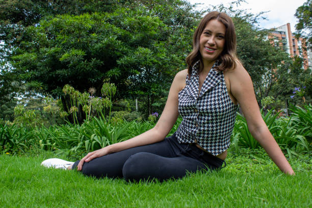 istock Beautiful woman modeling the grass in a public park 2204219417