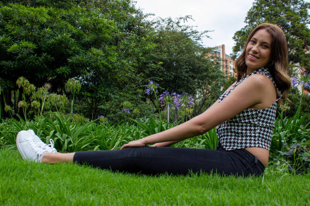 istock Beautiful woman modeling the grass in a public park 2204219456