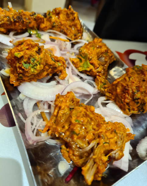 istock Savory snacks with a rich, spiced coating are plated alongside fresh onion slices at a bustling street vendor 2204220087