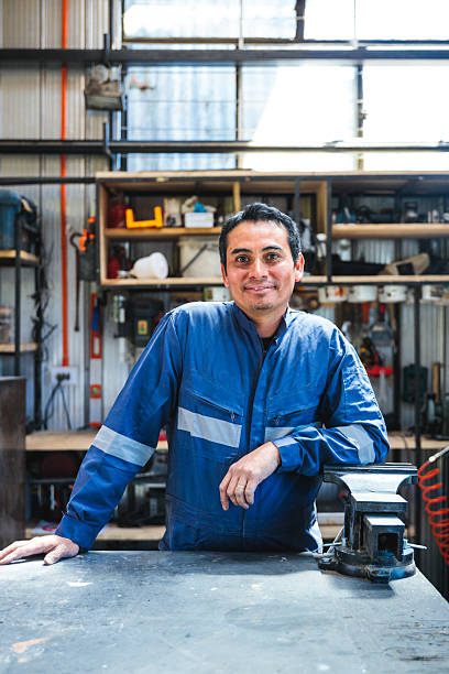Portrait of latin craftsman or carpenter smiling in his workshop with tools in background stock photo