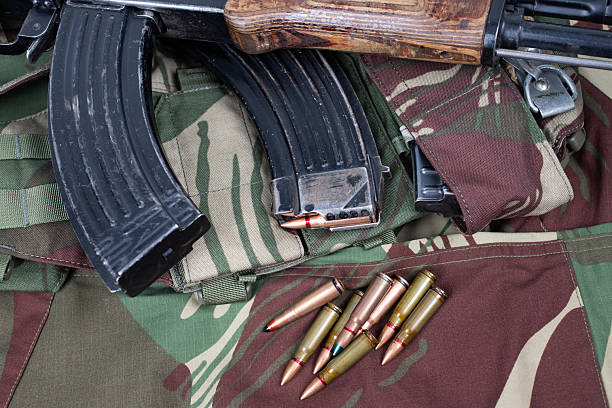 istock AK assault rifle on camo uniform background 2204225118