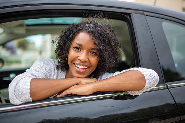 istock smiling young woman looking out car window 2204227036