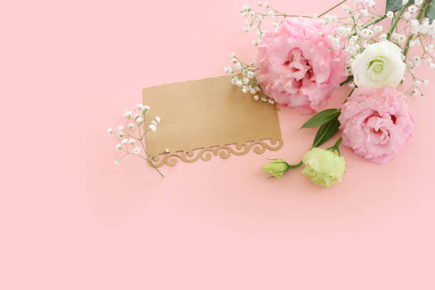 istock Top view image of pink flowers composition and empty note over pastel background 2204229054