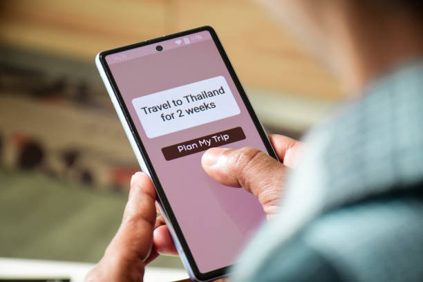 istock Man using mobile applications for trip planning to Thailand. Travel itinerary making using artificial intelligence concept. Selective focus. 2204232271
