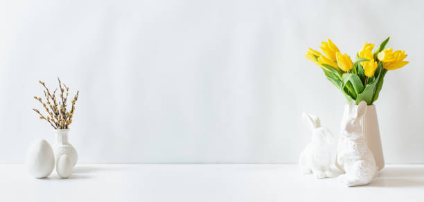 istock A white vase of yellow tulips and eggs on a white table 2204237455