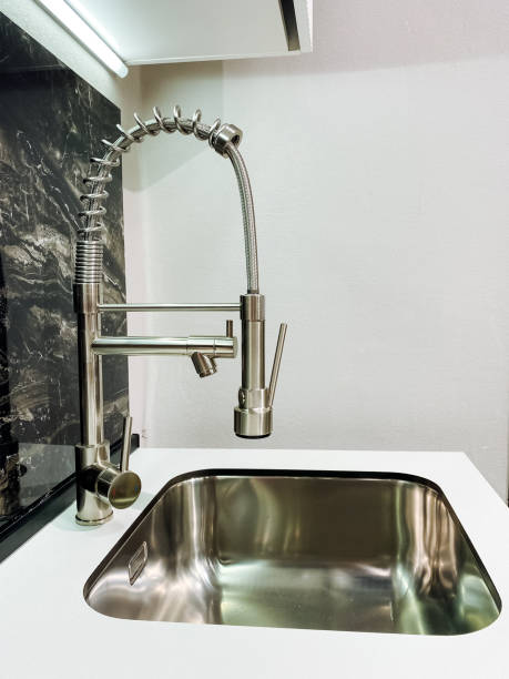 istock A thoughtfully designed stainless steel kitchen sink is complemented by a functional faucet, which is essential for both washing dishes efficiently and preparing food with ease 2204237976