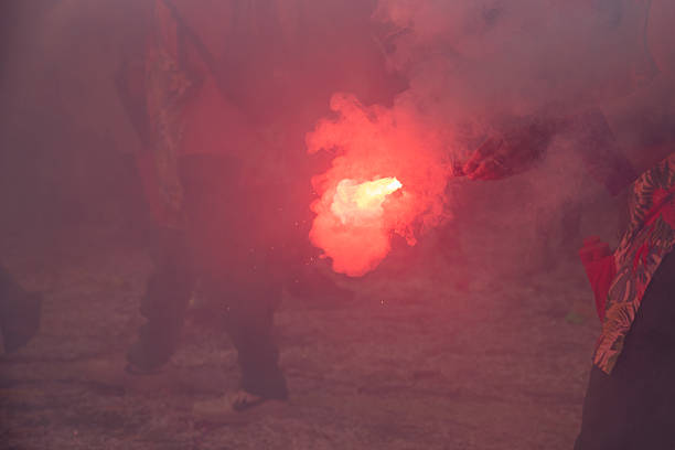 Protesters using red smoke flare during street demonstration