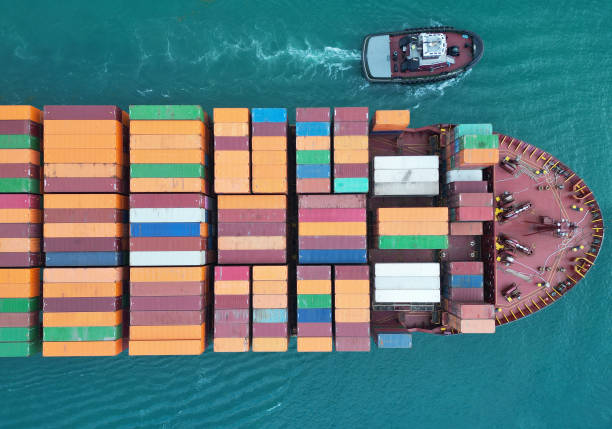 istock Cargo ship with container, top view. Freight container loaded on cargo vessel with tugboat. Aerial top view cargo ship with container. Cargo business. Container ship 2204239939
