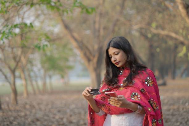 Indian Woman Making an Online Payment Using Smartphone and Credit Card