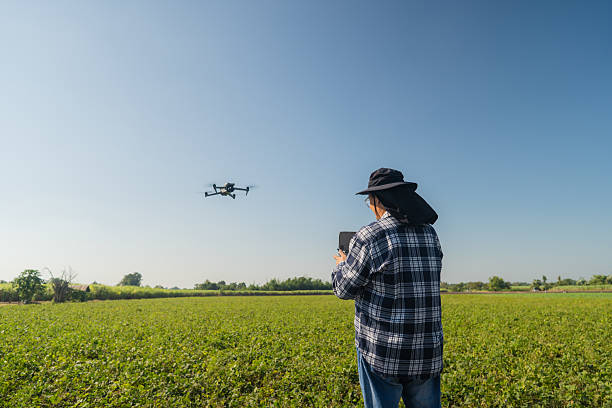 istock Man farmer and controlling of drone which flying above margin. 2204250561