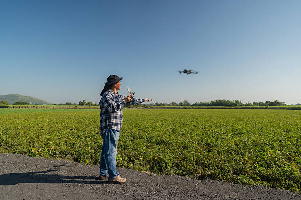 istock Man farmer and controlling of drone which flying above margin. 2204250585