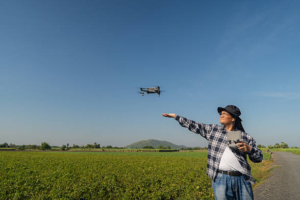 istock Man farmer and controlling of drone which flying above margin. 2204250611