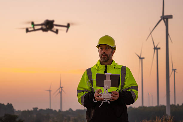 istock Engineers male flying drone surveying wind turbines. 2204250629